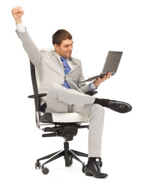 Young businessman sitting in chair with laptop clipart