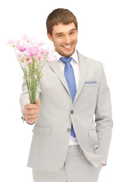 Knappe man met bloemen in de hand — Stockfoto
