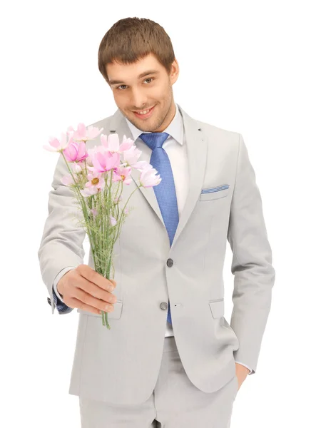Przystojny mężczyzna z kwiatów w ręku — Zdjęcie stockowe