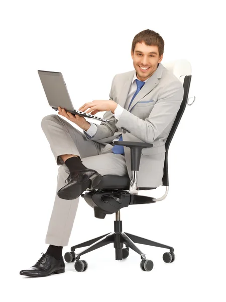 Young businessman sitting in chair with laptop — Stock Photo, Image