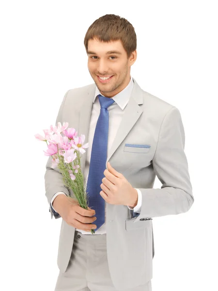 Knappe man met bloemen in de hand — Stockfoto