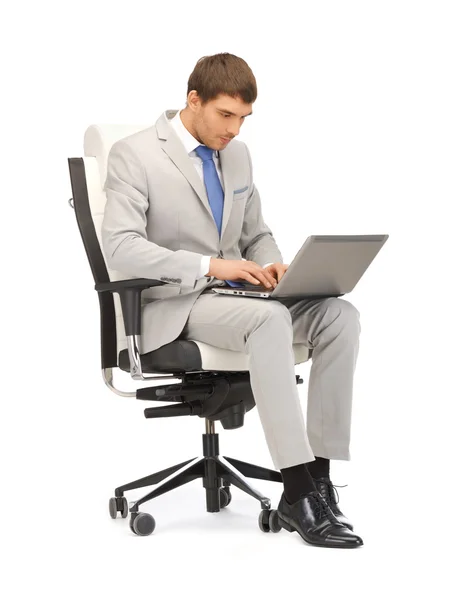 年轻的商人坐在椅子上用的笔记本电脑 — 图库照片