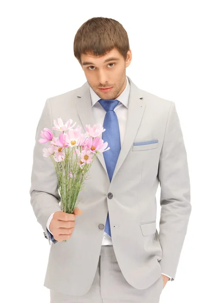 Handsome man with flowers in hand — Stock Photo, Image
