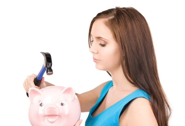 Teenage girl with piggy bank and hammer Royalty Free Stock Photos