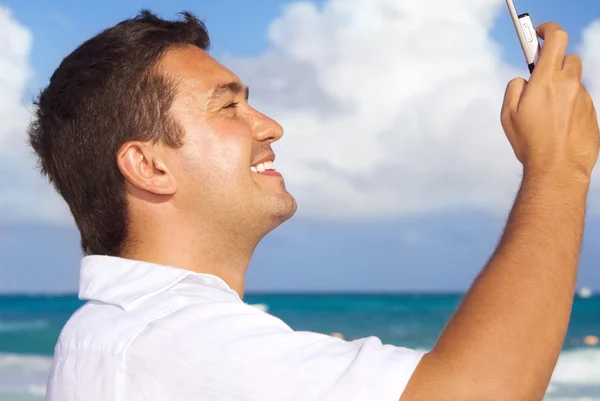 Ευτυχισμένος άνθρωπος με τηλέφωνο στην παραλία — Φωτογραφία Αρχείου