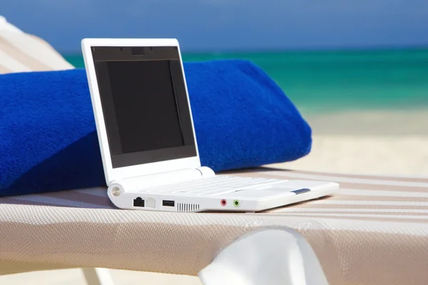 Laptop a ručník na lehátko pláži — Stock fotografie
