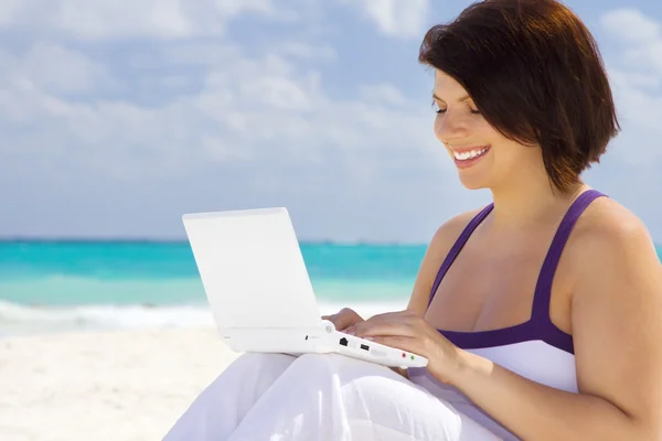Жінка з ноутбуком на пляжі — стокове фото