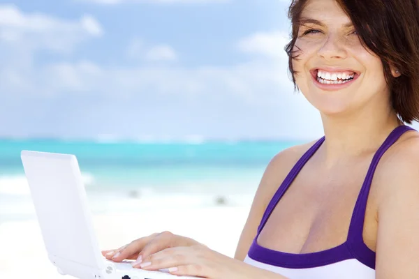 Donna con computer portatile sulla spiaggia — Foto Stock