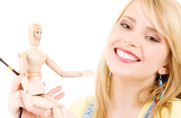 Happy teenage girl with wooden model dummy — Stockfoto