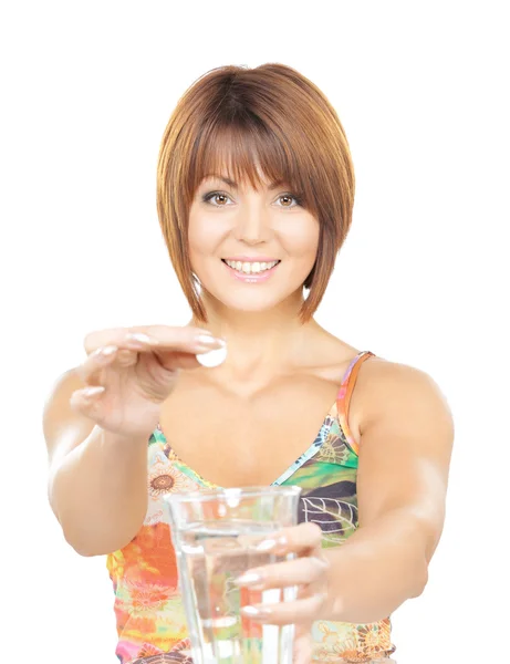 Женщина с таблетками и стаканом воды — стоковое фото