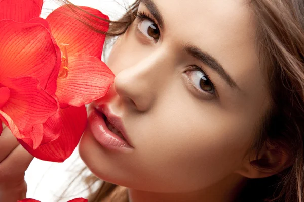 Mulher encantadora com flores vermelhas — Fotografia de Stock