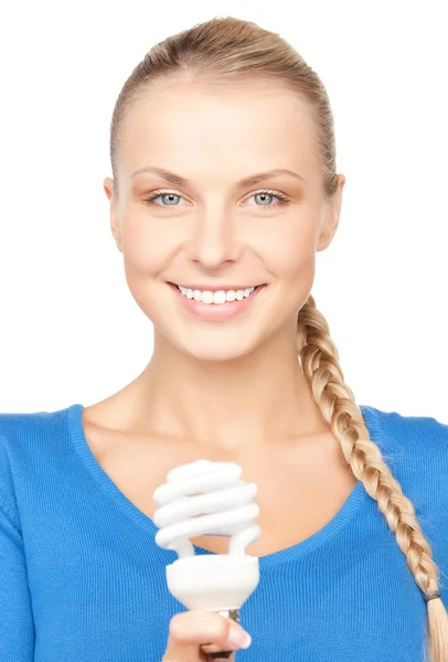 Женщина держит энергосберегающую лампочку — стоковое фото