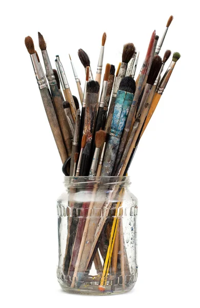 stock image Assorted dirty painting brushes in glass flask