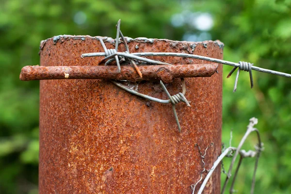Rusty column with barbed wire — Stockfoto