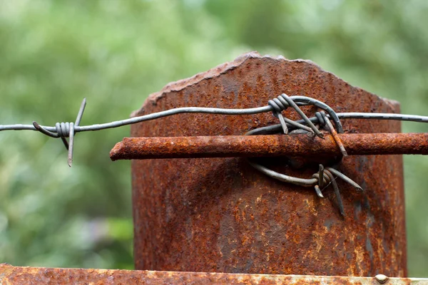 Rusty column with barbed wire — Stock Photo, Image