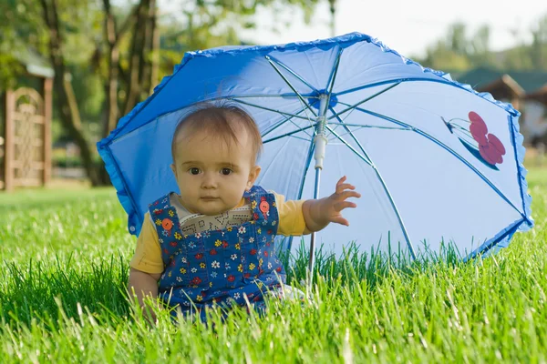 Няня сидит под зонтиком — стоковое фото