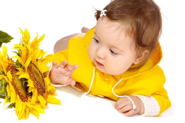 Baby looking at sunflowers — Stock Photo, Image