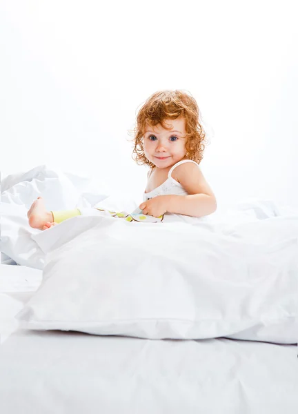 巻き毛の幼児の女の子のベッドで — ストック写真