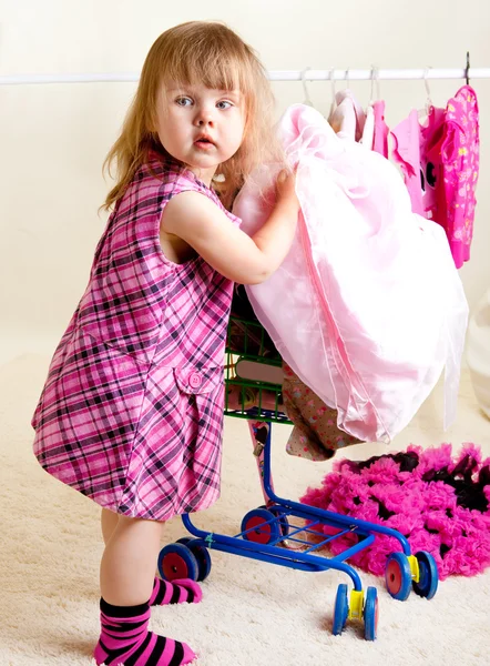 Dívka uvedení oblečení do vozíku — Stock fotografie