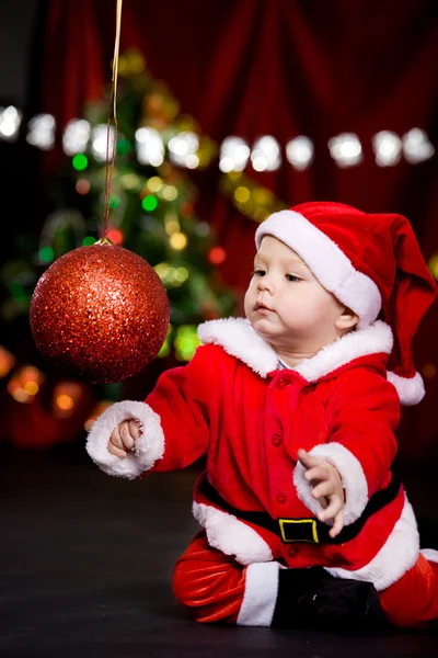 Санта-помощник играет с рождественским мячом — стоковое фото