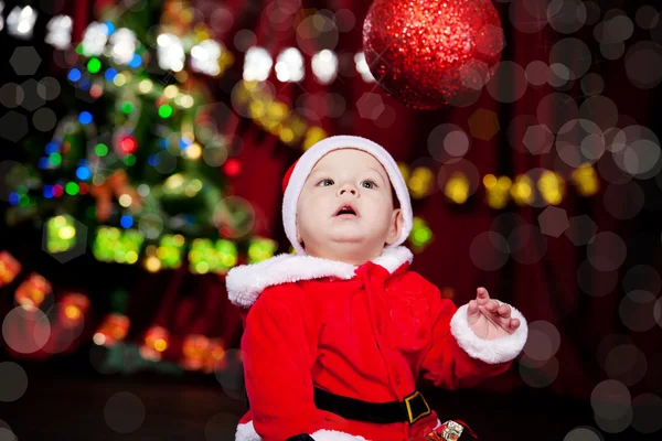 Kind schaut Weihnachtskugel an — Stockfoto