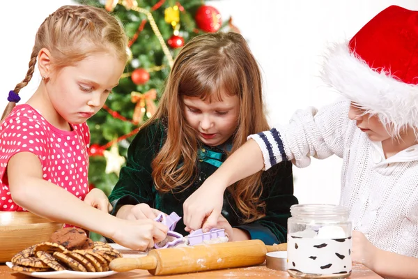 Kinder schneiden Weihnachtsplätzchen — Stockfoto