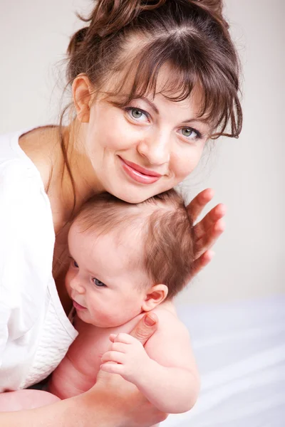 Любящая мама с ребенком на руках — стоковое фото