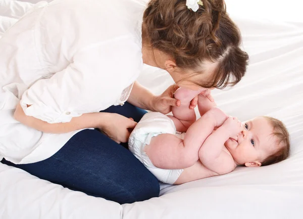 Mutter küsst Baby den Fuß — Stockfoto