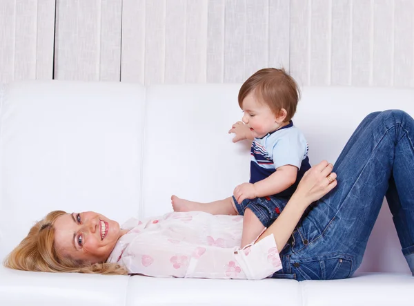 Moeder liggen spelen met baby zoon — Stockfoto