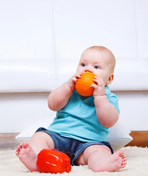 幼児のオレンジをかむ — ストック写真