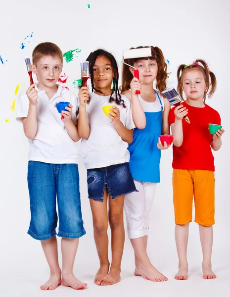 Crianças segurando pincéis e tintas — Fotografia de Stock