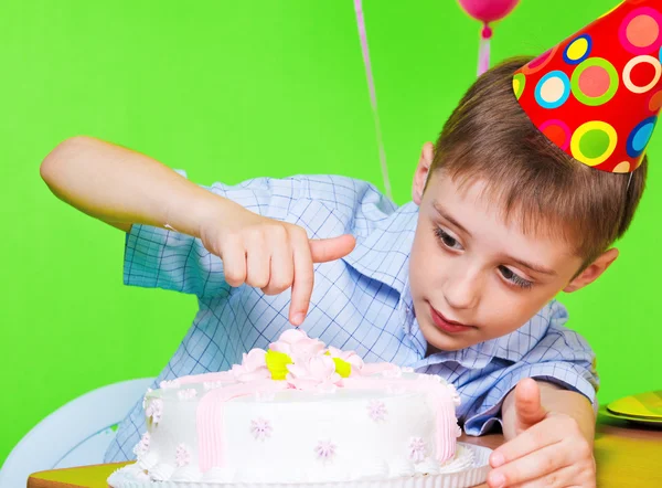 Chlapec ochutnávka narozeninový dort — Stock fotografie