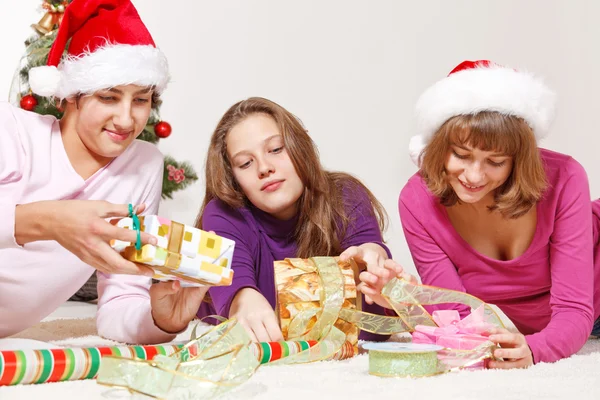Lächelnde Studenten in Weihnachtsmützen lizenzfreie Stockbilder