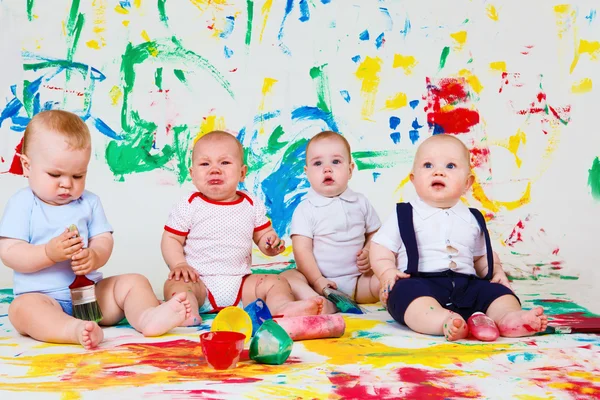 Babies with paints and paintbrushes — Stock Photo, Image