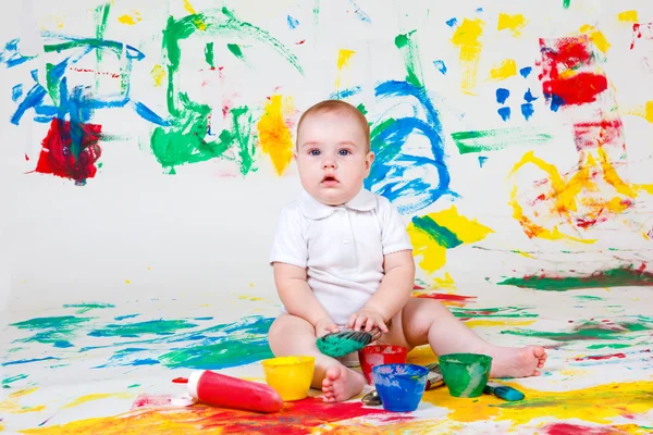 Curious baby playing with paints — Stock Photo, Image