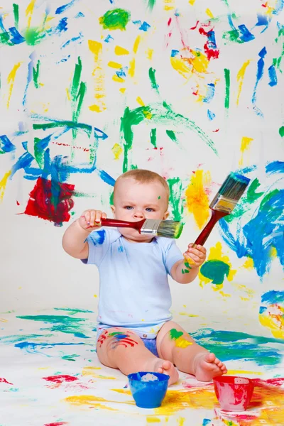 Baby playing with paintbrushes — Stock Photo, Image