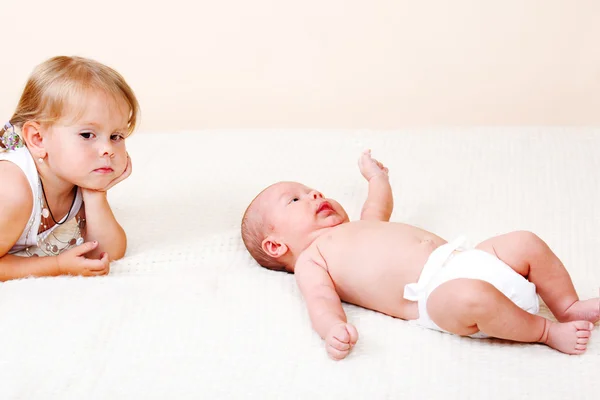 Маленькая девочка и новорожденный ребенок — стоковое фото
