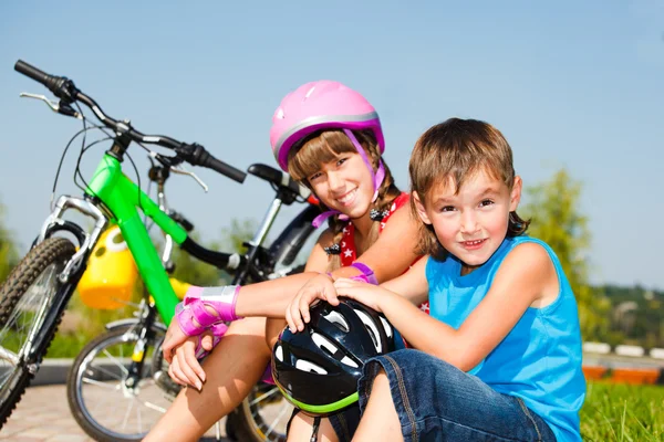 Мальчик и его сестра в защитных велосипедных шлемах — стоковое фото