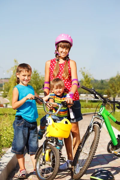 Сестра и братья с велосипедами — стоковое фото