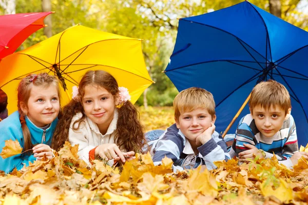 Ομάδα παιδιά κάτω από μια ομπρέλα — Φωτογραφία Αρχείου