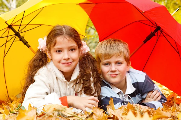 Мальчик и девочка лежат на желтой листовке — стоковое фото