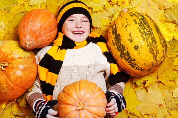 Jongen op yeallow herfst bladeren — Stockfoto