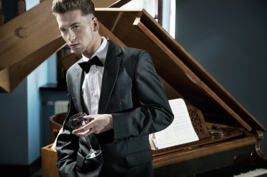 Young pianist with glass of wine clipart