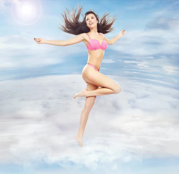 Foto conceptual de una guapa morena corriendo en las nubes — Foto de Stock