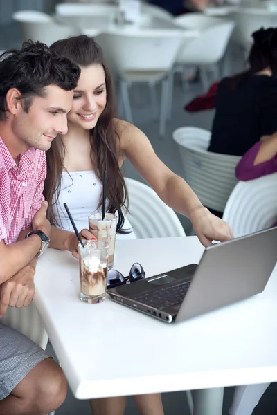 Älskande par beter internet på en restaurang — Stockfoto