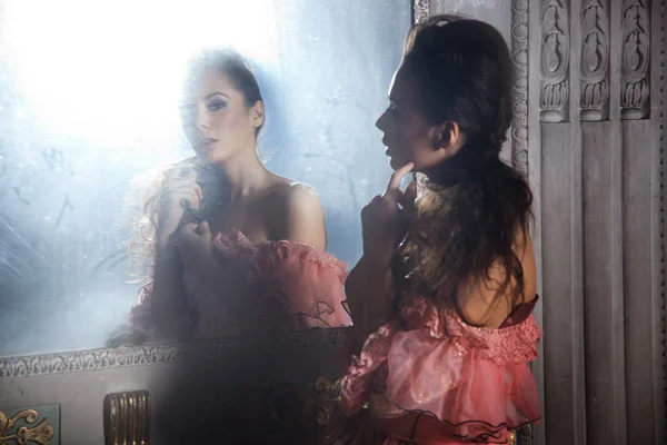 Krásná bruneta stojící vedle zrcadla — Stock fotografie