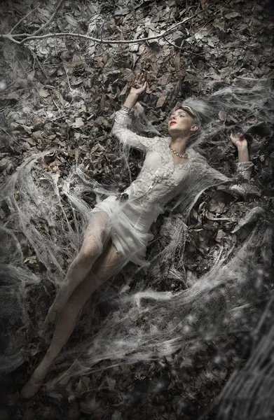 Изобразительное фото сексуальной женщины, лежащей на листьях — стоковое фото