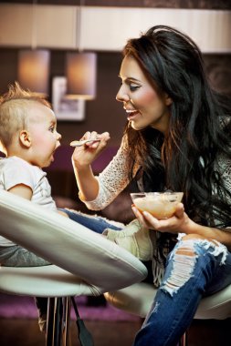 Mum feeding her baby clipart