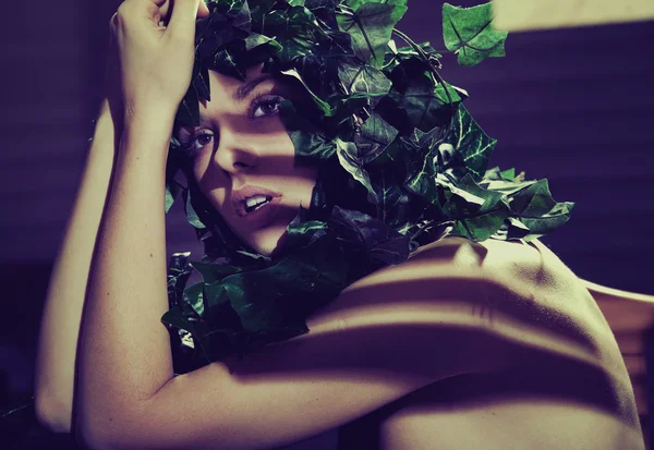 Изобразительное фото женщины с зелеными листьями в прическе — стоковое фото