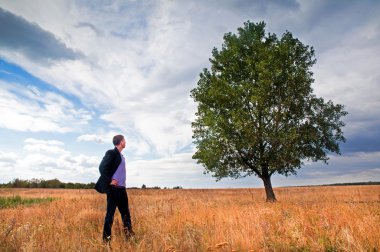 Young businessman and big tree clipart